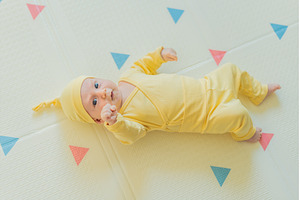 Adorable baby in a yellow hat lying, a Person Photo by Elizaveta Galitskaya