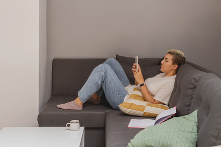 Woman lies on sofa with smartphone, a Person Photo by Valeriia • Svitlini
