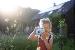 Little girl taking photos outdoors, a Nature Photo by HalfPoint