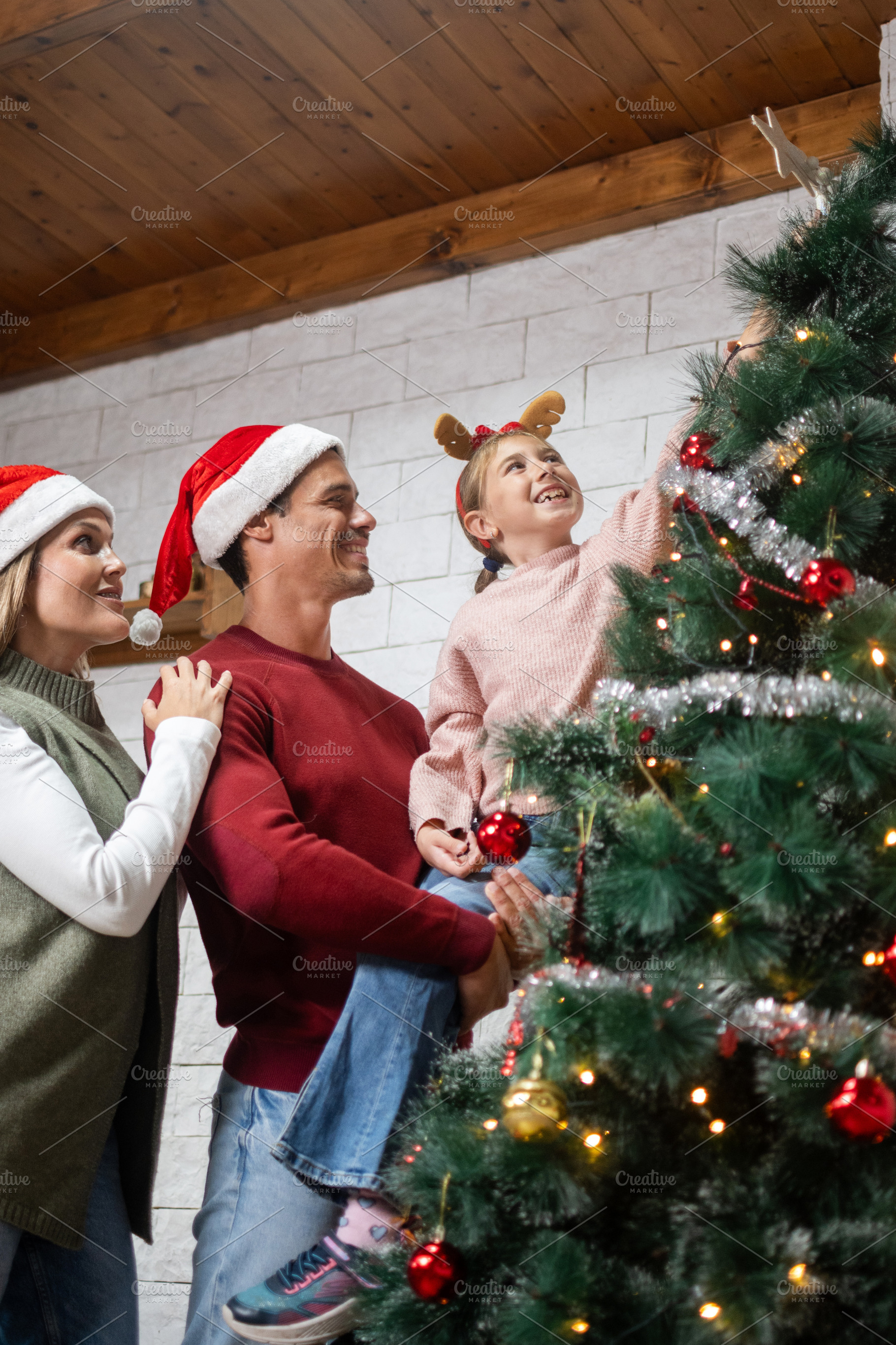 Happy family decorating Christmas tree together, a Person Photo by etorres69