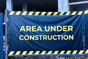 Construction site banner warning area under progress with striped border design, a Photo by AS photostudio