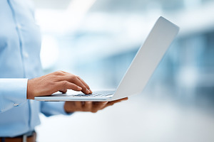 Man in a blue shirt using a laptop, a Business Photo by MistyDay