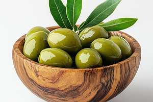 Green olives in wooden bowl with lea, a Food & Drink Photo by Pixeness Studio