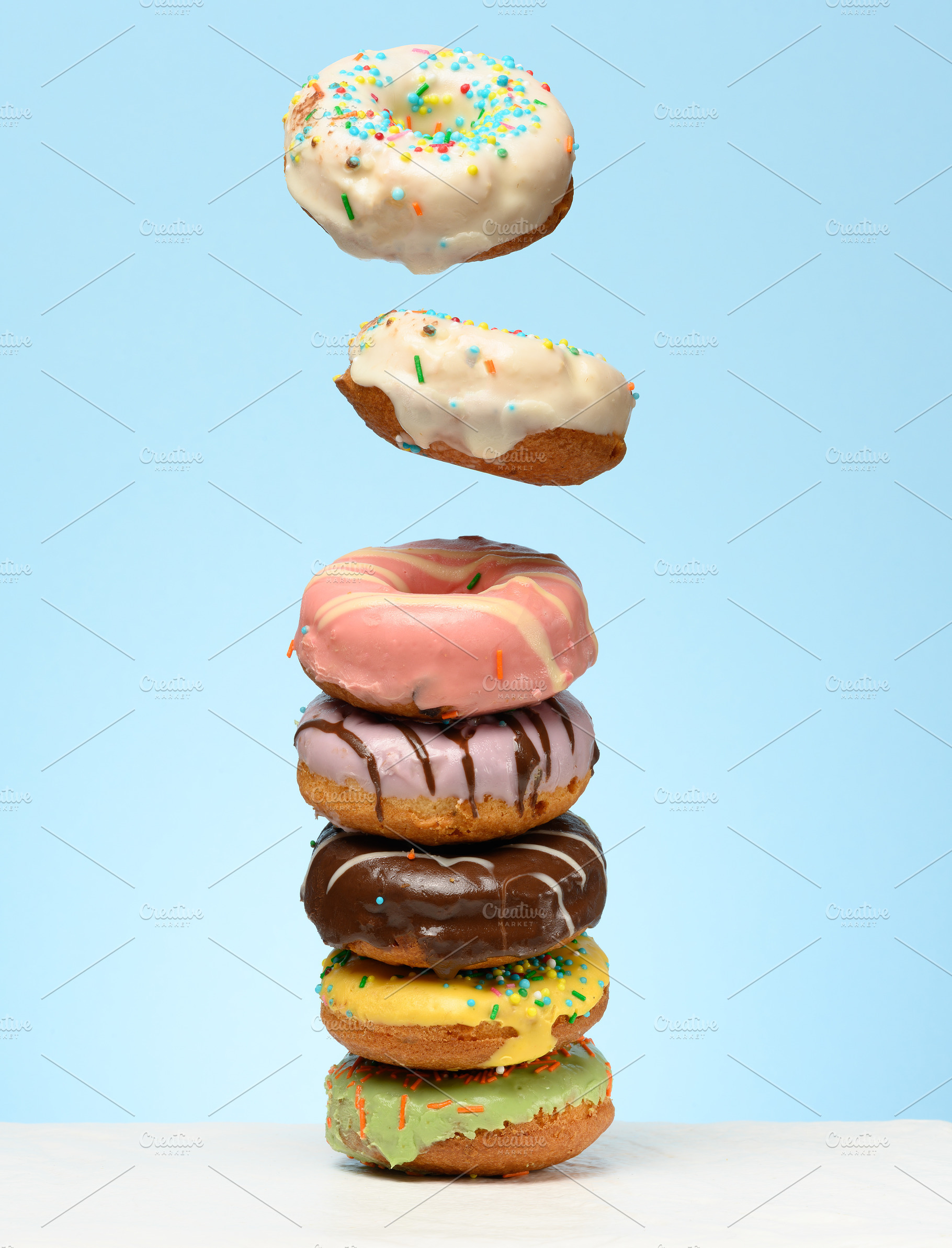 A stack of donuts with various fillings and glazes, several levi, a Food & Drink Photo by ndanko