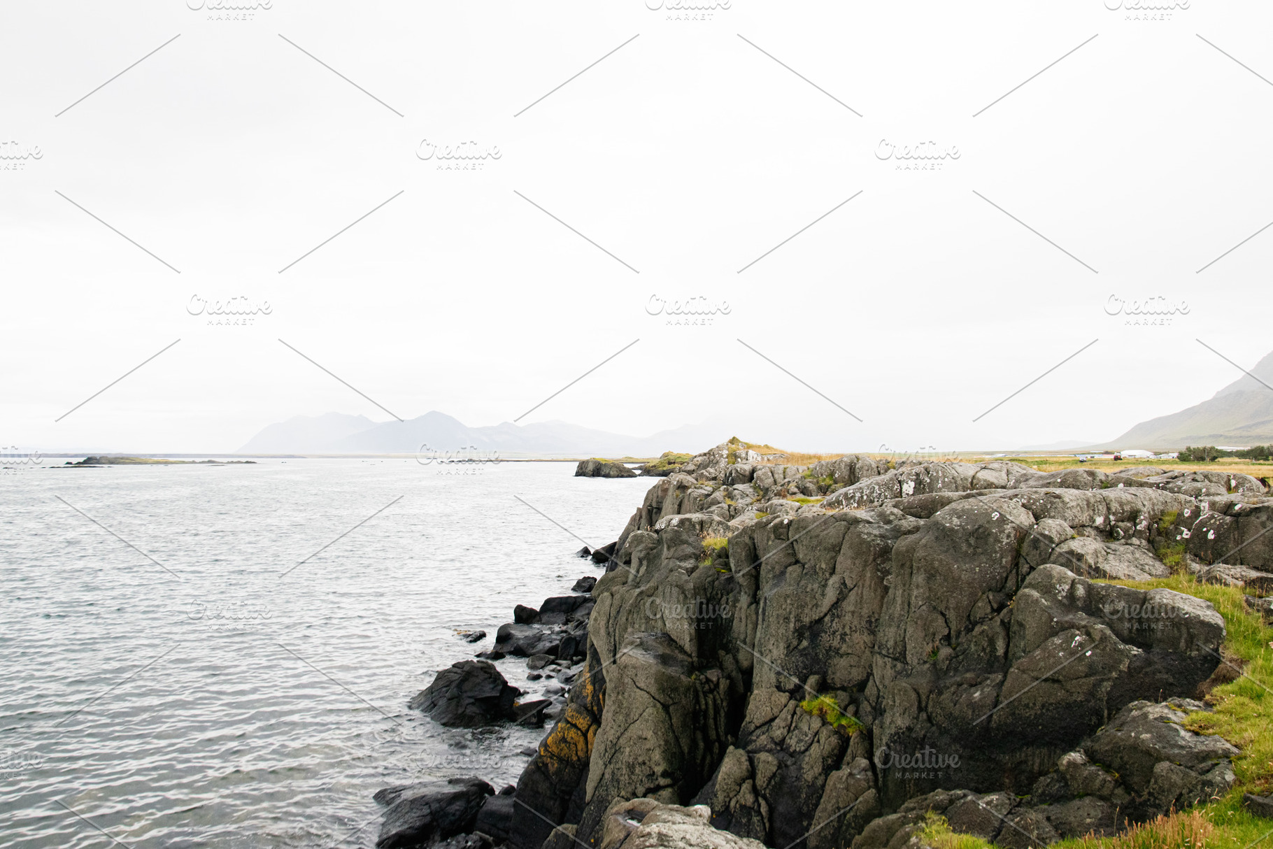 Rocky coastline overlooking the sea with Icelandic mountain landscape in the di, a Nature Photo by AS photostudio