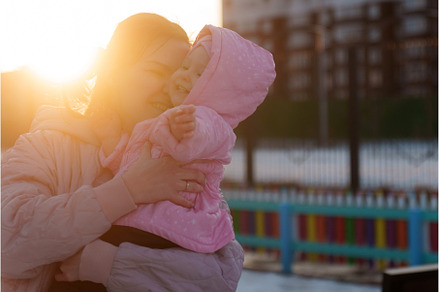 Mother embraces child at sunset in