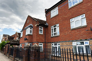 Residential red brick apartments with iron fence and sidewalk un