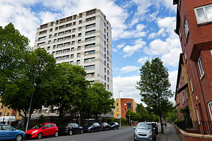 Residential apartment building and parked cars on a tree lined u