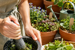 Woman preparing herbal mixture with, a Photo by Dvoevnore photos