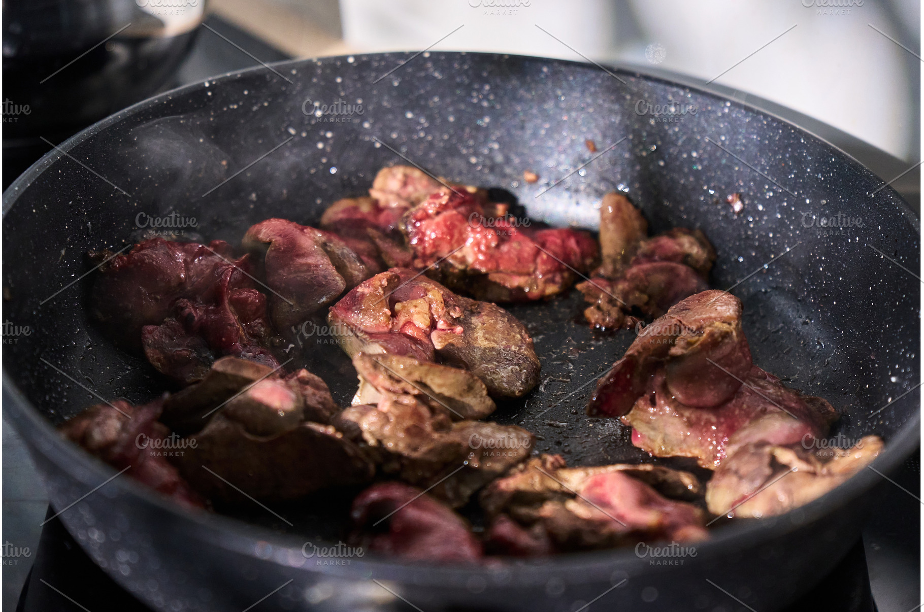 Sliced liver sizzles in a pan with, a Background Photo by darksoul72