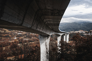 Curved bridge over autumn valley, an Architecture Photo by SkyNext