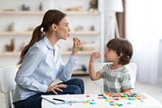 Young woman speech therapist studying together with small kid, learning practic, a Photo by Prostock-Studio (Thumbnail 2 of 2)