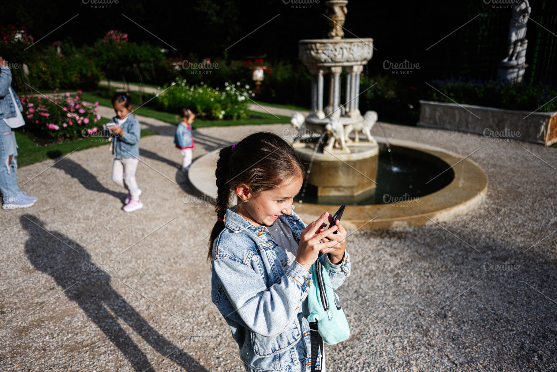 Children exploring technology in a park with a fountain, Lancut, Poland, a Photo by AS photostudio