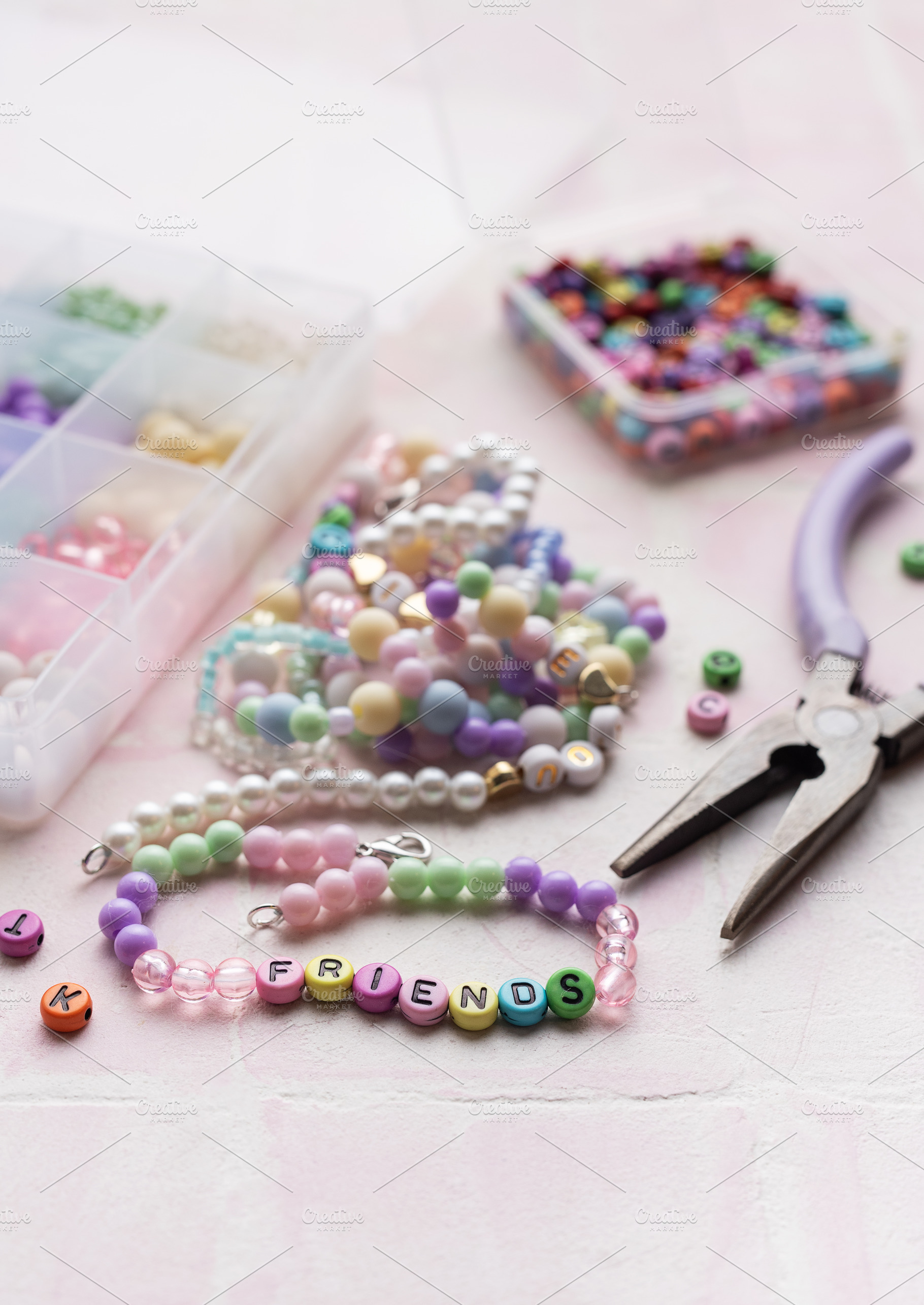 Colorful beads and pliers arranged on pink tile for jewelry maki, an Arts & Entertainment Photo by Olena Rudo