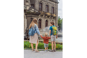 Mother with her two sons standing, an Architecture Photo by Elizaveta Galitskaya