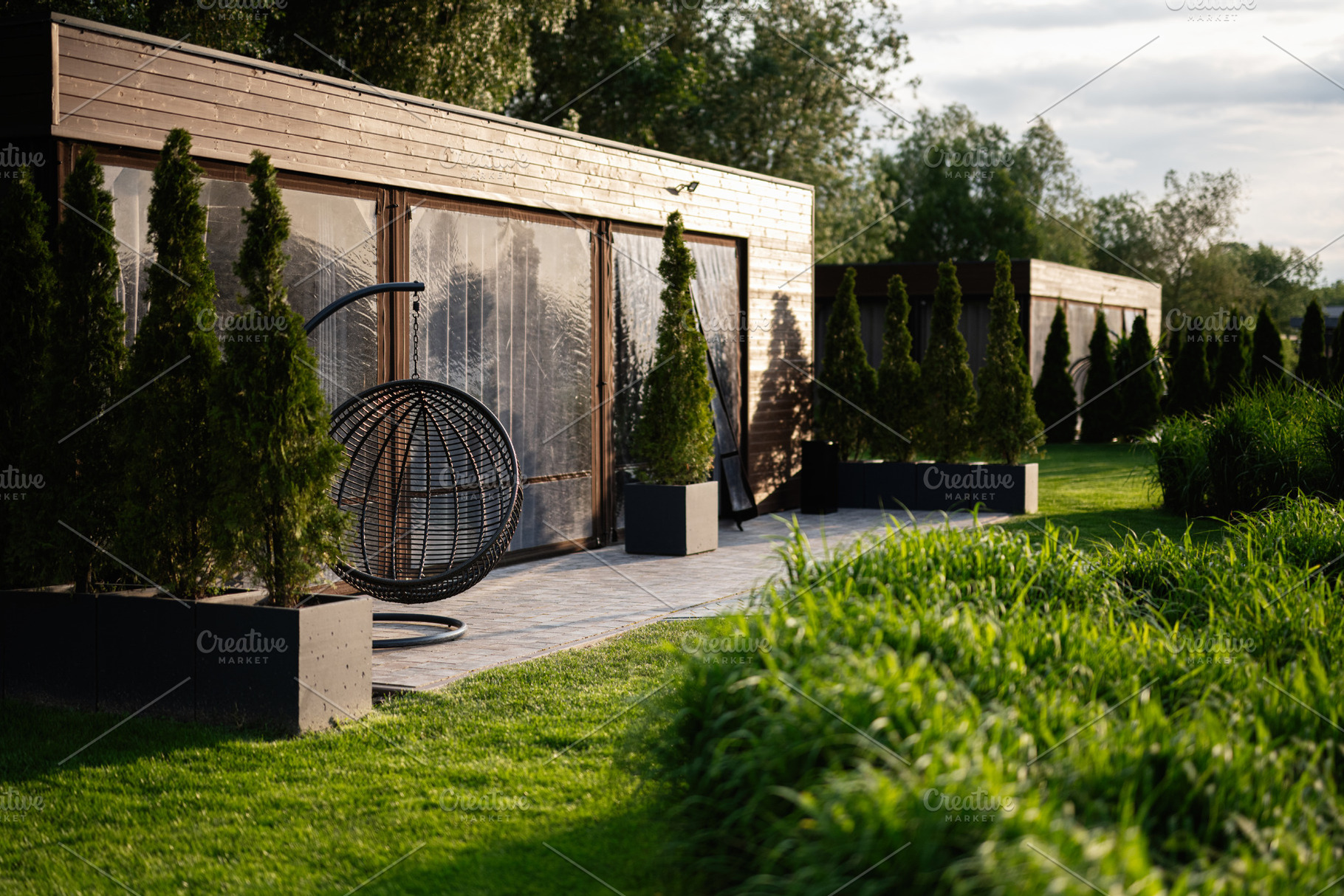 Modern outdoor patio with greenery and stylish seating arrangement, a Photo by AS photostudio