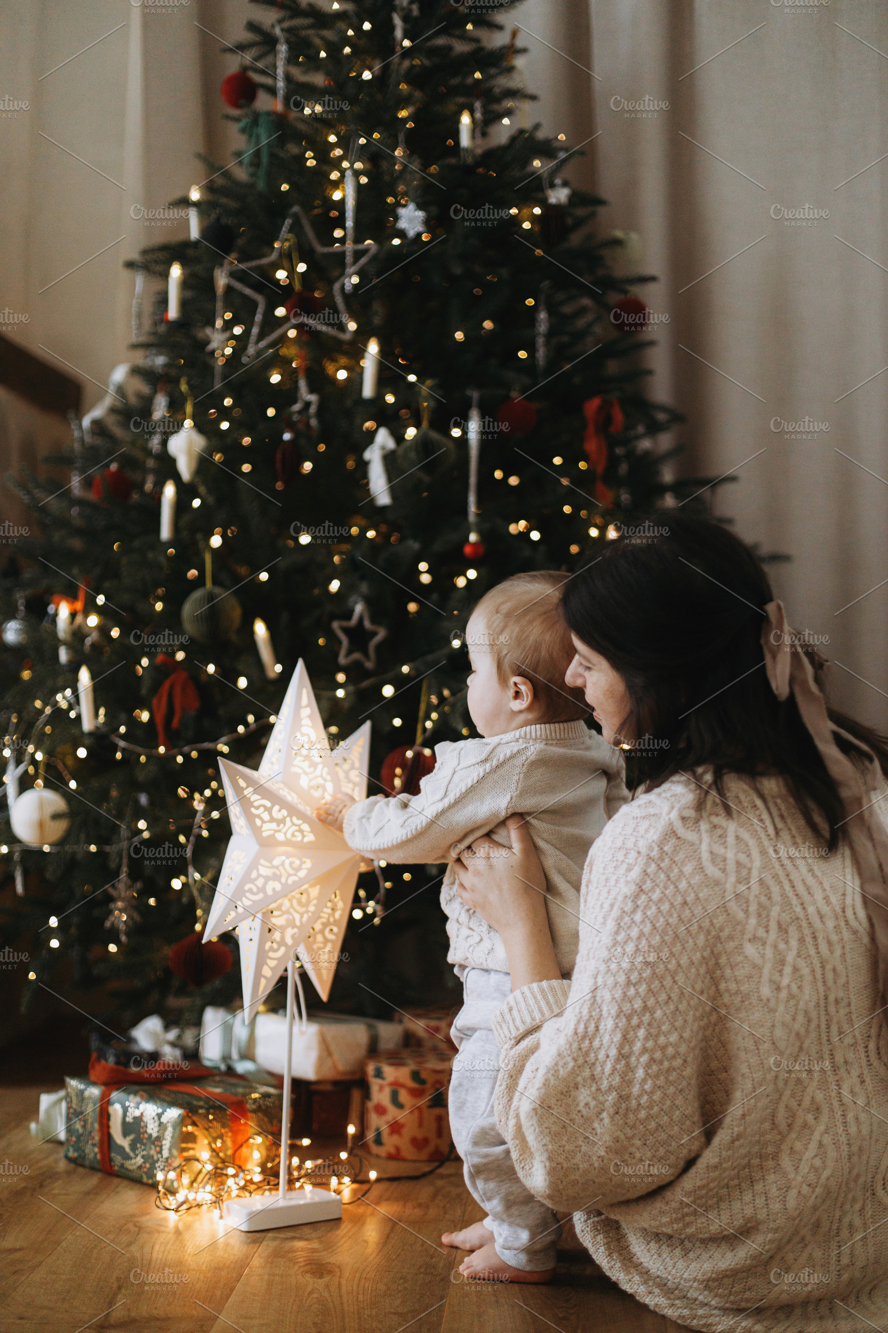 Stylish mother and baby son in knitted sweaters sitting together, a Holiday Photo by Sonjachni