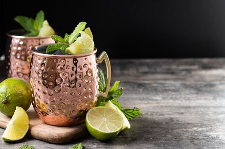 Moscow mule cocktail served with ice and lime slice on wooden table, a Food & Drink Photo by etorres69