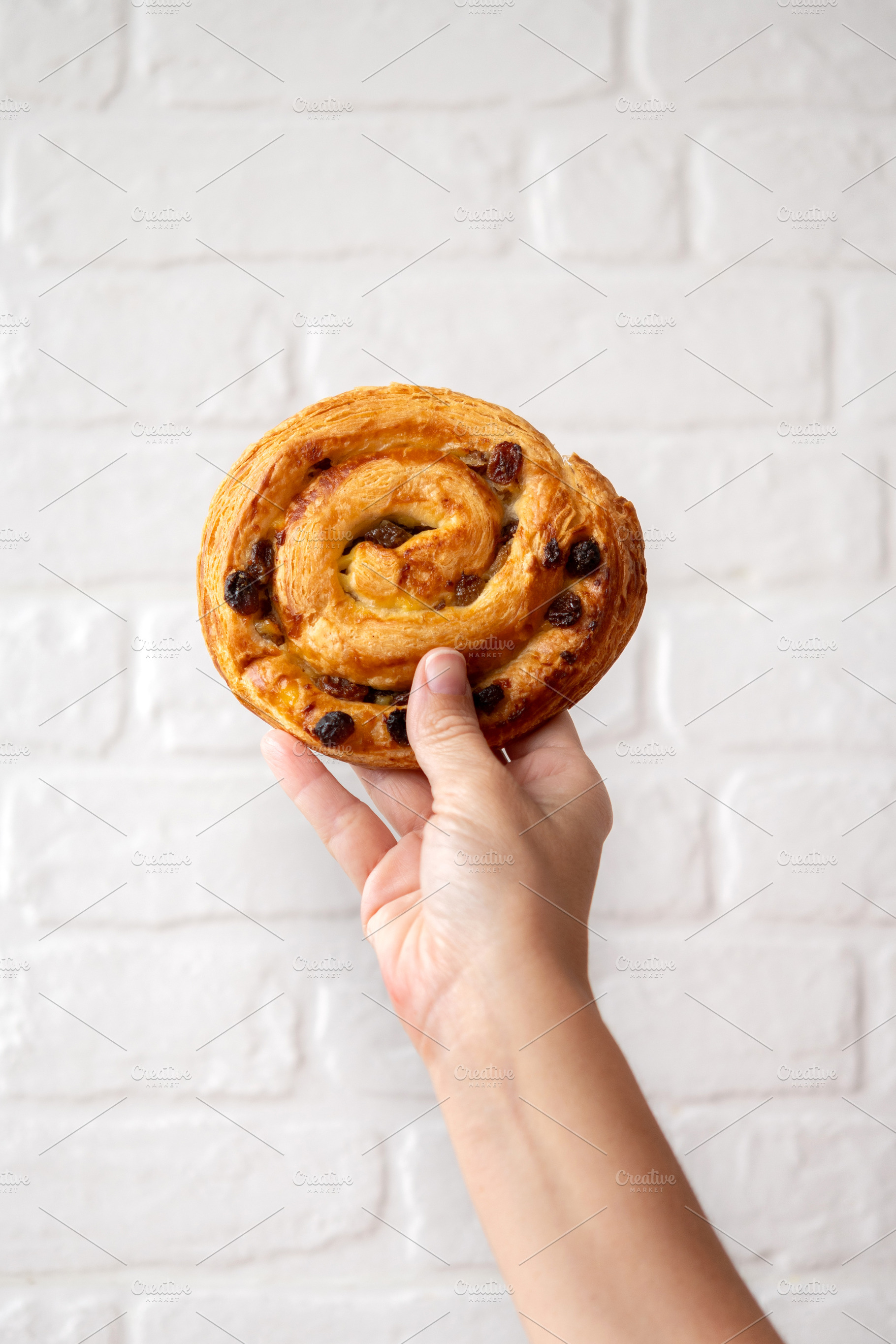 Hand Holding Raisin Danish Pastry, a Food & Drink Photo by etorres69