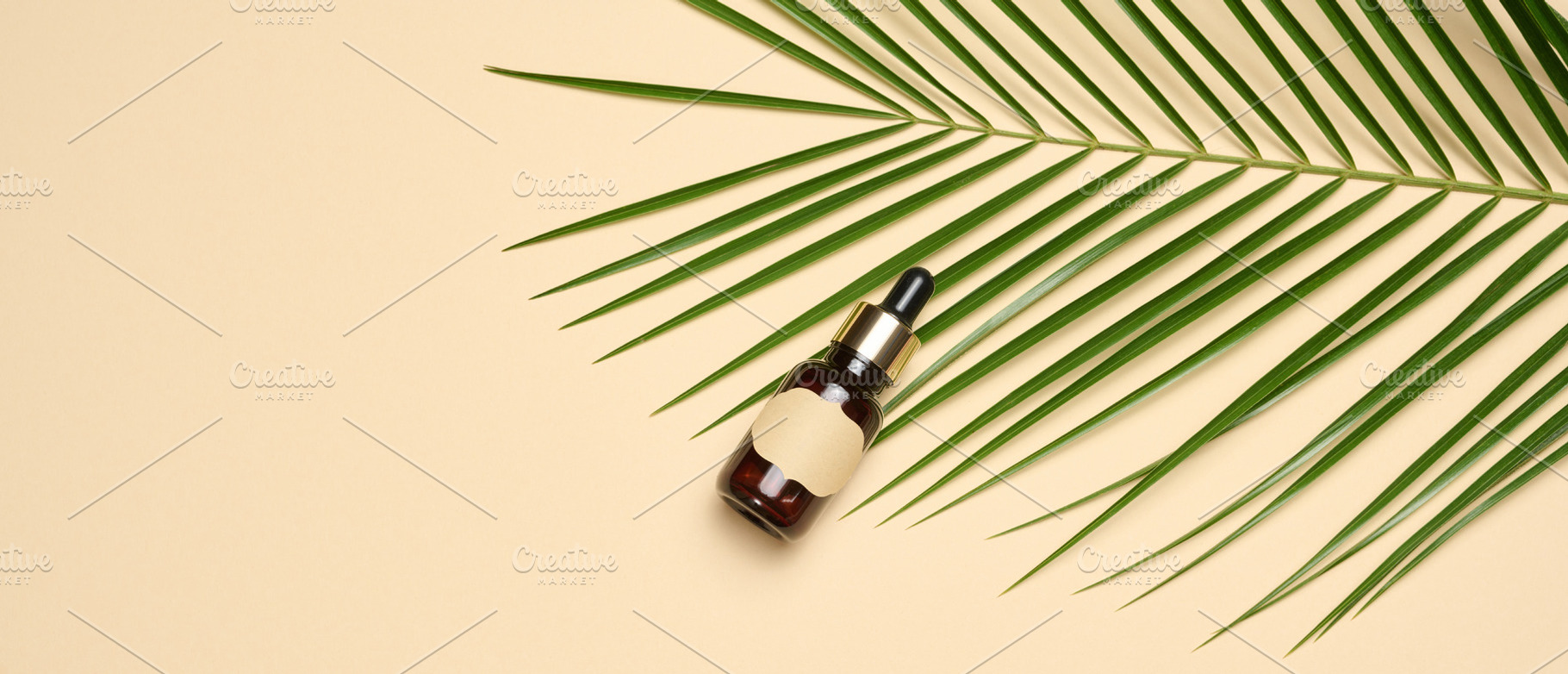 A glass dropper bottle with a clean label lies next to a green p, a Beauty & Fashion Photo by ndanko