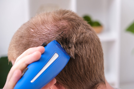 A man cuts his hair with clipper. Cutting a short hairstyle at home. Close-up., a Technology Photo by Detriana