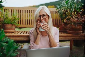 Older woman having cup of tee while, a Person Photo by HalfPoint