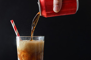 Person filling glass with cola from a can isolated background, a Food & Drink Photo by Davizro's Market