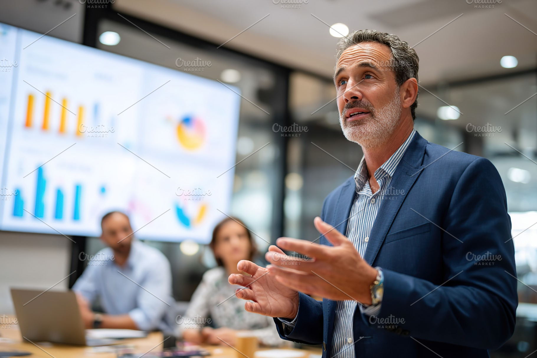 Business professional in formal suit presents during a meeting in modern office, a Business Photo by AlyaAnd