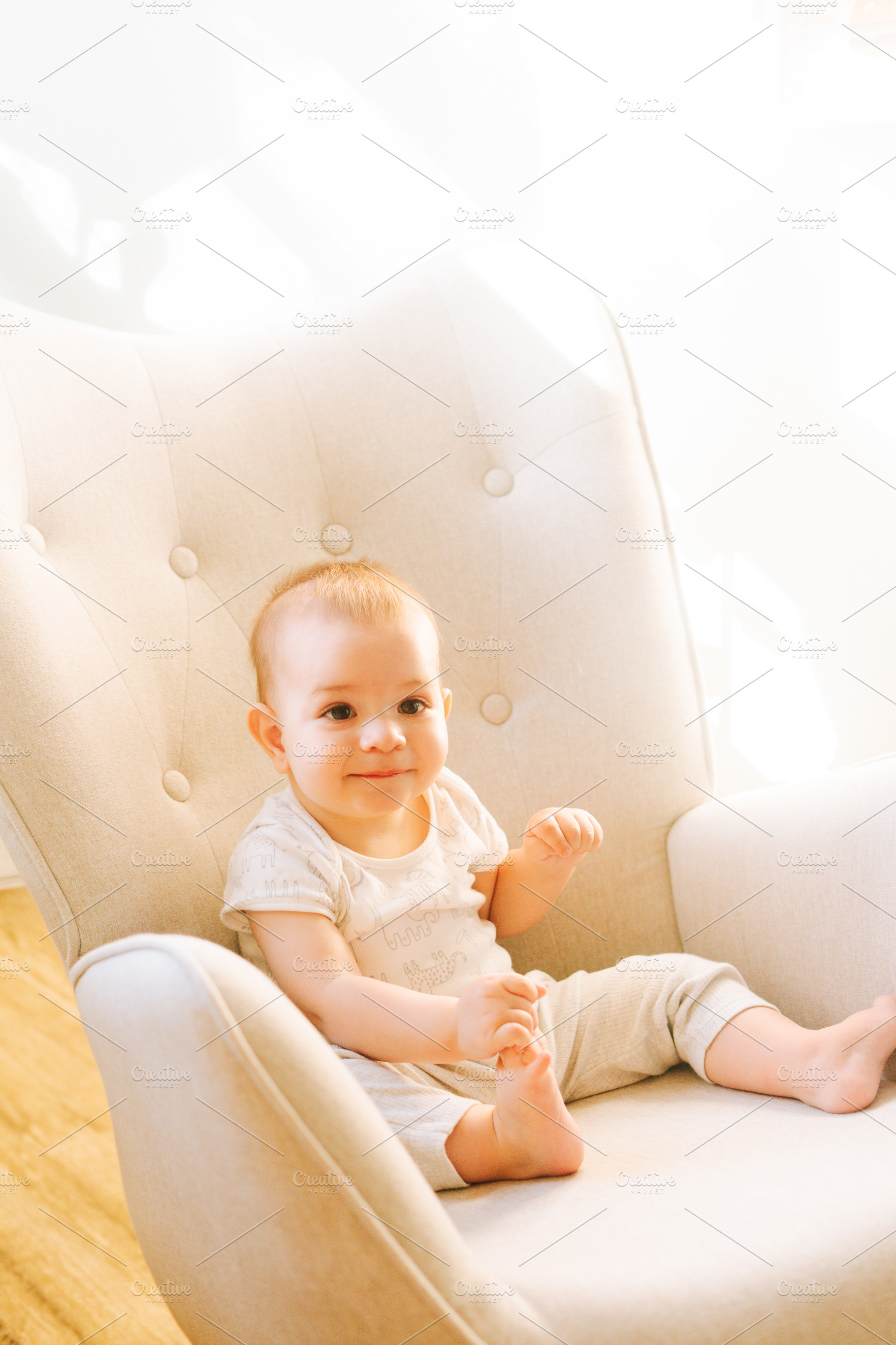 Portrait of a nine month old baby sitting in a rocking chair, a Person Photo by rubenchase
