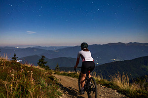 Young cyclist riding on a mountain trail at starry night, a Sports & Recreation Photo by DanFLCreativo