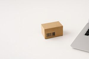 Cardboard box and laptop on white ba, a Photo by Dvoevnore photos