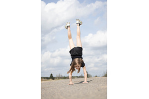 Little girl stands on her hands, a Nature Photo by Nenahliadava Design