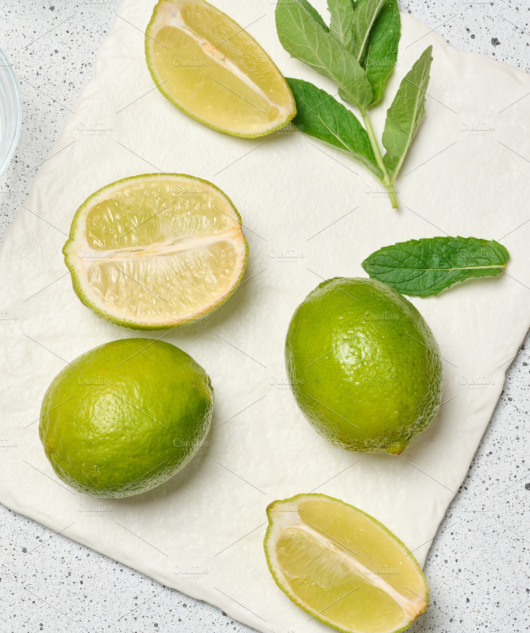 A minimalist composition featuring green whole limes and a juicy, a Food & Drink Photo by ndanko