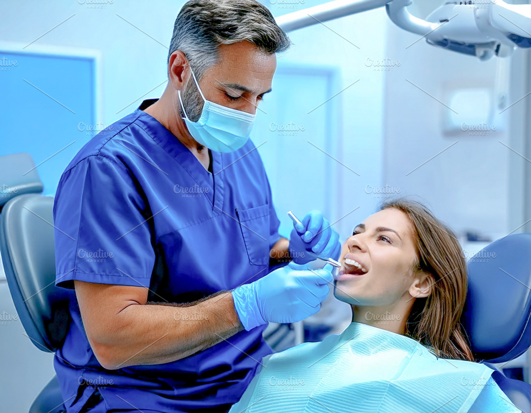Male dentist performing treatment on patient, a Health & Medical Photo by DanFLCreativo
