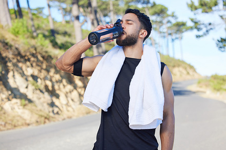 Water, fitness and exercise with a sports man drinking from a bottle for hydration during his workout or training routine. Health, wellness and rest with a male athlete taking a break from a routine, a Photo by Peopleimages.com