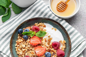 Granola bowl with yogurt, berries, and mint for breakfast, a Food & Drink Photo by Olena Rudo