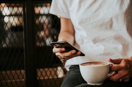 woman using iphone with coffee