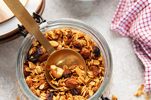Granola with nuts and dried fruits in jar, a Food & Drink Photo by Olena Rudo