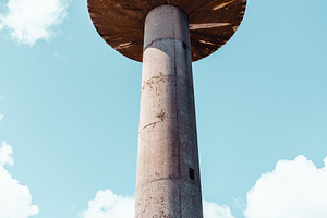 Concrete water tower against sky, an Architecture Photo by SkyNext