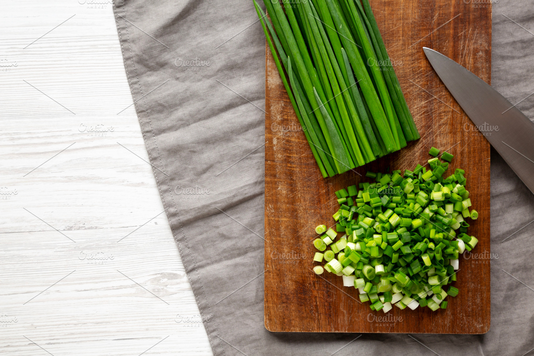 Organic Cut Green Onion Scallions on a Wooden Board, top view. C, a Food & Drink Photo by LiudmylaChuhunova