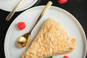 Sliced Napoleon cake on a white wooden table. Classic dessert, a Food & Drink Photo by Budarinphoto