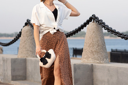 Woman walks stylishly holding hat