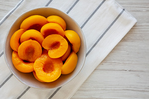 Healthy Organic Canned Peach Halves in a Bowl, top view., a Food & Drink Photo by LiudmylaChuhunova
