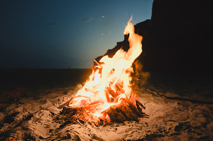 Fire burning on the beach featuring beach, nature, and people