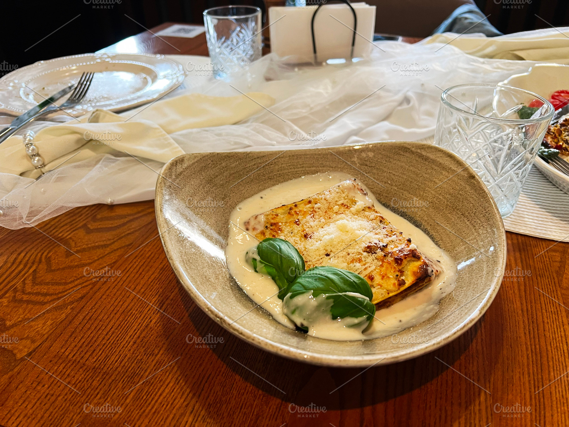 Close-up of a delicious lasagna plate served on a rustic wooden table, a Photo by AS photostudio