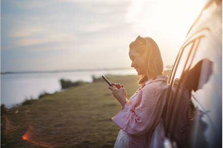 Young woman scrolling phone, leaning, a Transportation Photo by HalfPoint