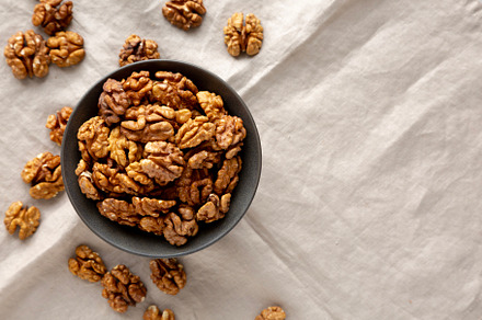 Raw Walnut Halfs in a Bowl, top view. Copy space.