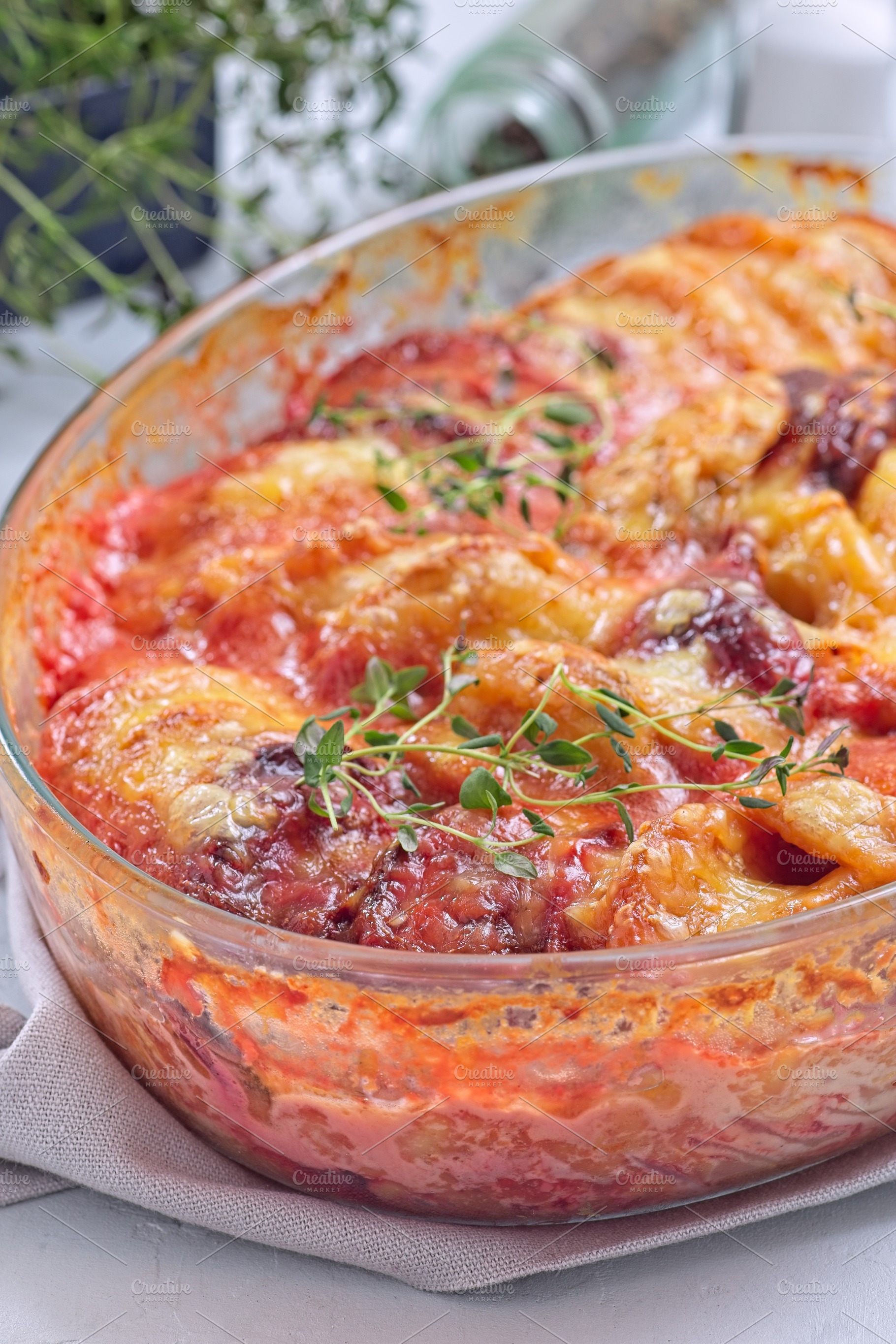 Sweet potato, parsnips and beet root au gratin, in glass dish, vertical, a Food & Drink Photo by iuliia_n