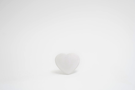 White heart on a white background in the center of the frame. Minimalism. Copy