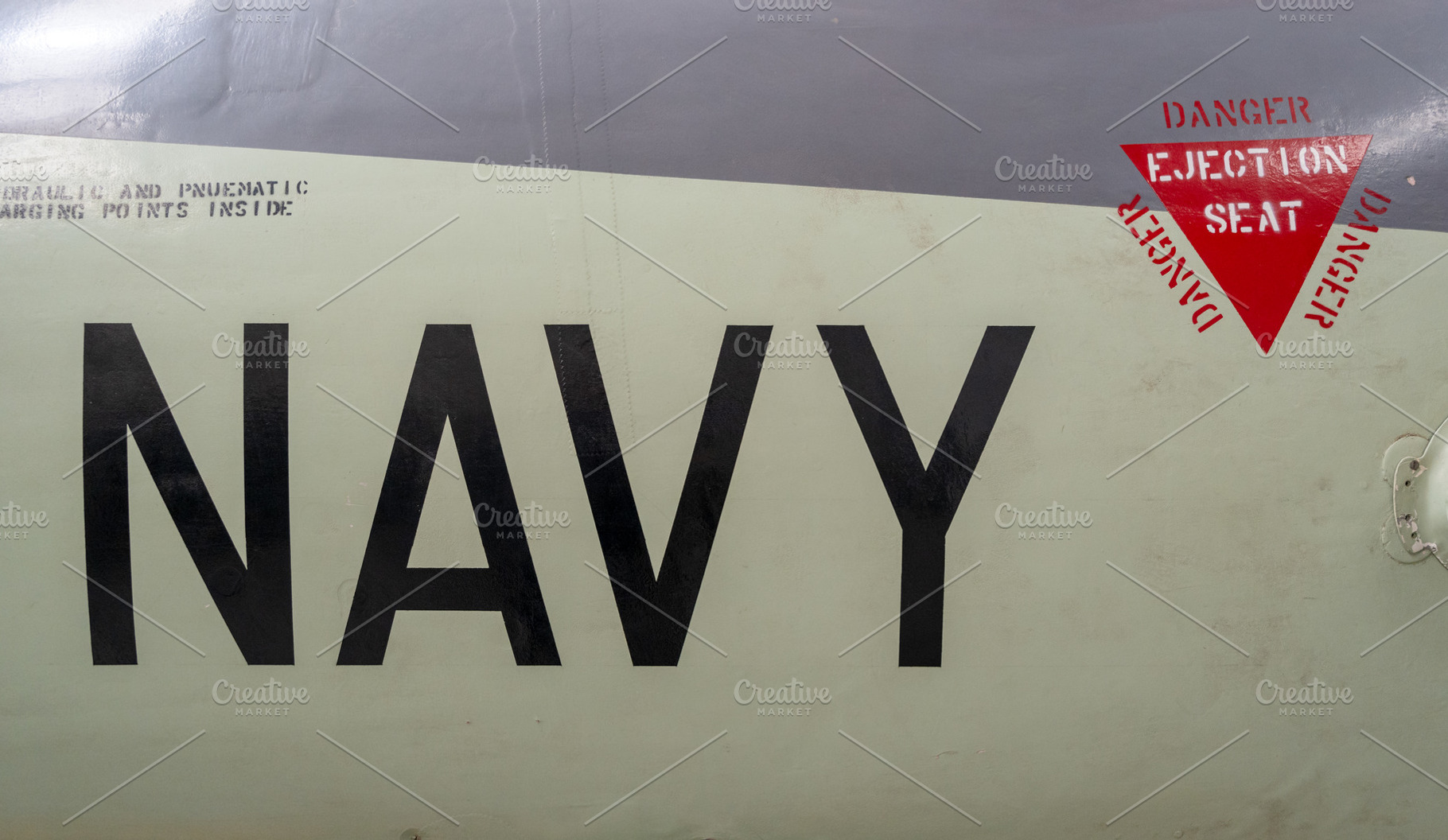 Vintage aircraft fuselage with navy markings and ejection seat w, an Abstract Photo by GoodGoods